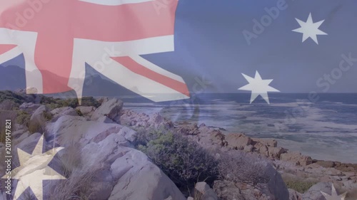 On start Australian flag rippling over rocky headland, revealing coastline, symbolizing identity