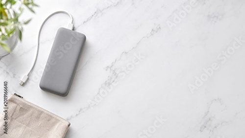 Portable charger on marble surface next to a cloth bag  