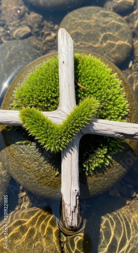 Mossy heart, weathered wood cross, serene river rocks