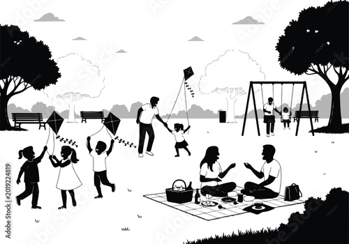 Family and children playing kites in a park with a picnic blanket