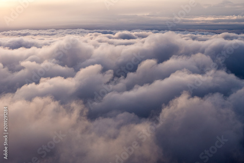 Aerial view of dense cumulus clouds with soft sunlight at sunset over Mono County, California, United States.