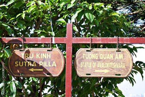 Foto Wooden direction signs to Sutra Pillar and Statue of Avalokiteshvara in a tropic