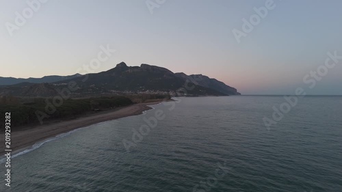Calm sea and sandy shoreline at Spiaggia del Lido delle Rose in Sardinia under soft evening light, drone