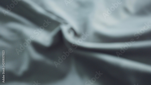 Tableau sur toile Abstract blurred background featuring soft, flowing folds of gray fabric with a subtle silky texture