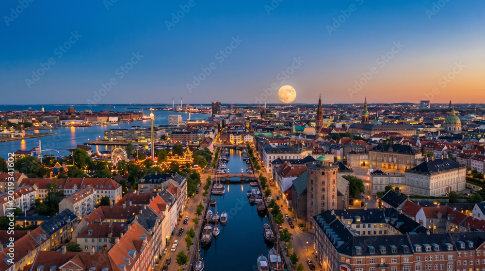 Fototapeta premium Panoramic aerial view of Copenhagen canals and cityscape at dusk with a full moon rising.
