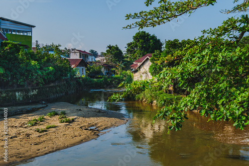 Photos Sedimentation and receding water levels in a river or canal near residential are