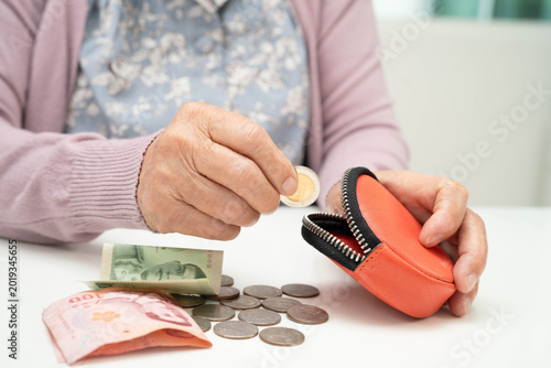 Foto Asian senior or elderly old lady woman holding counting coin money in bag
