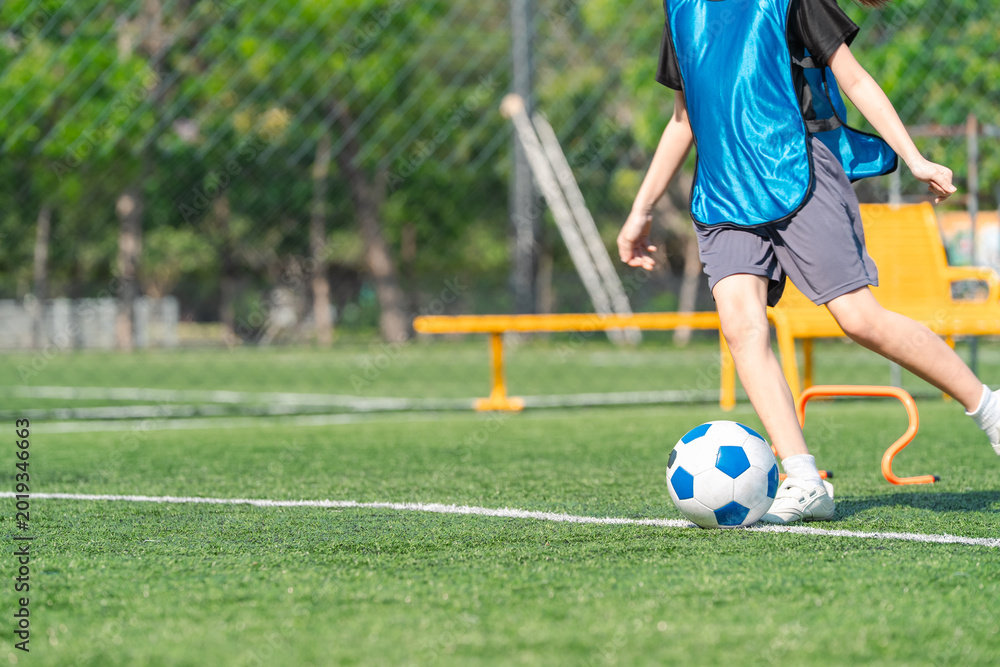 Obraz premium World cup concept with soccer or football player, soccer ball child kick field grass sport training outdoor play leg