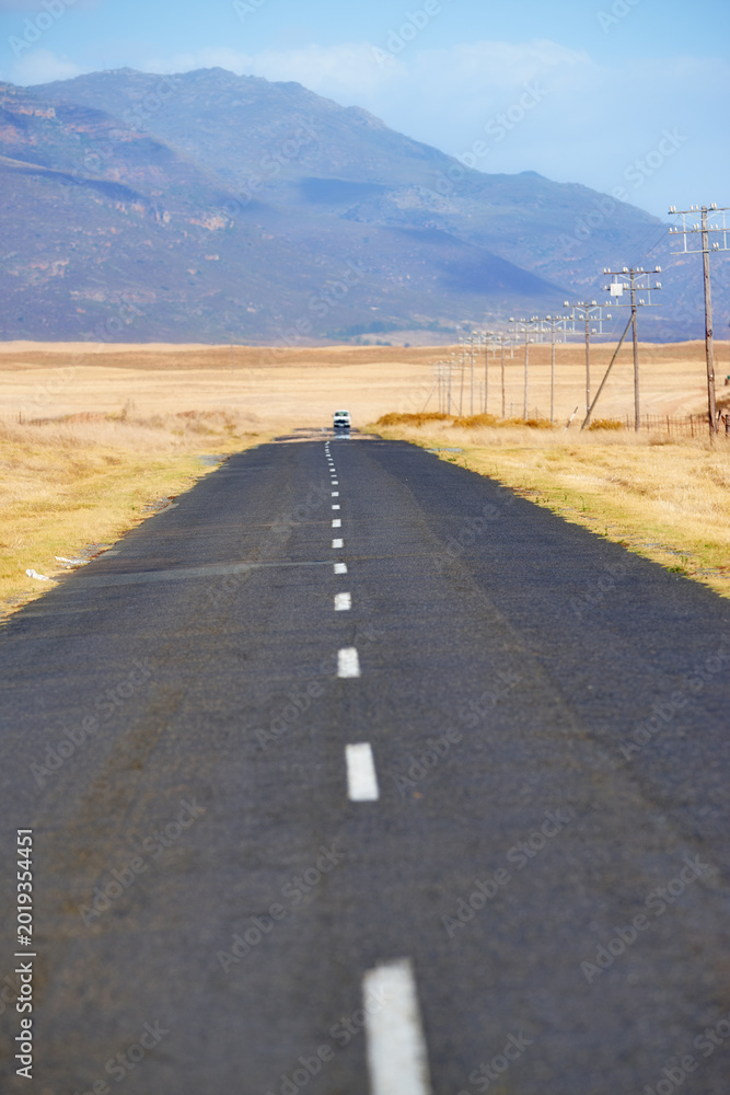 Obraz premium Landscape, empty and road with mountain for travel, tourist destination and journey outdoor. Nature, background and street with route, highway and space for vacation, trip and holiday with vehicle