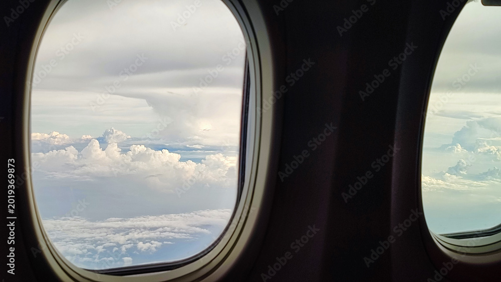 Fototapeta premium Cloud View from Airplane Window Above the Sky During Flight