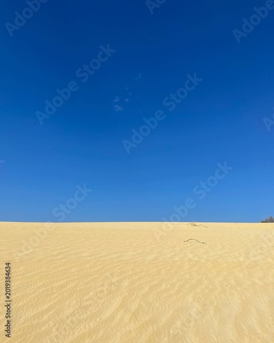 Minimal blue sky and yellow sand background