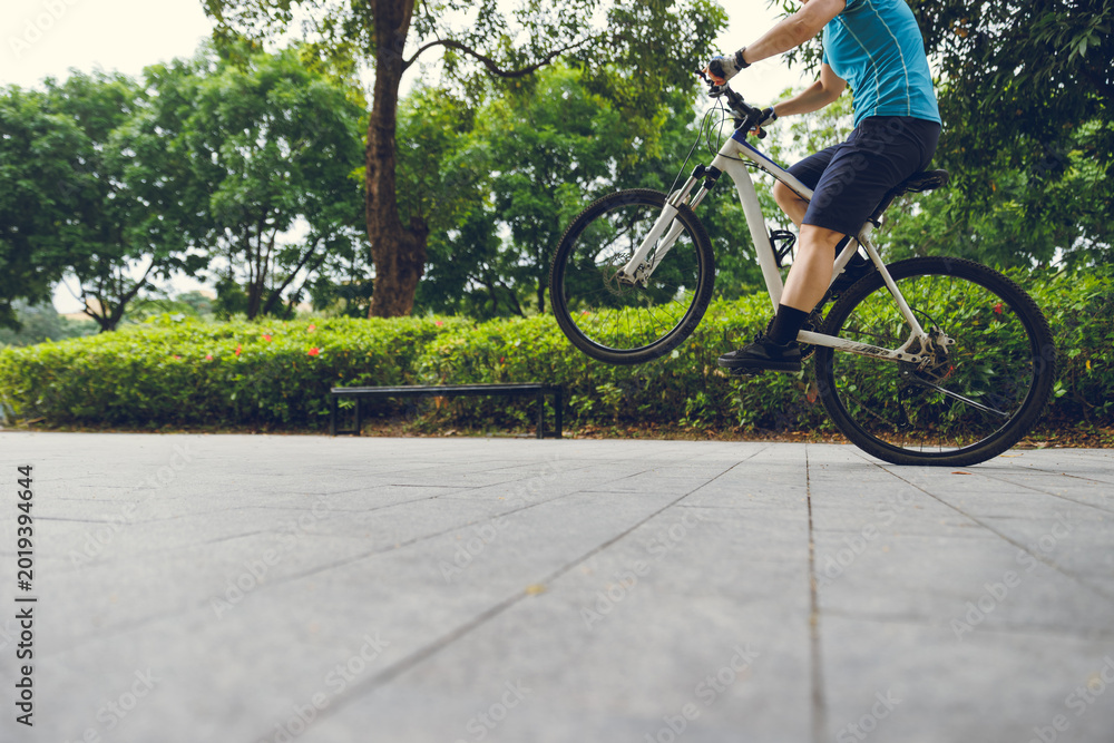 Naklejka premium People practice wheelie in the park
