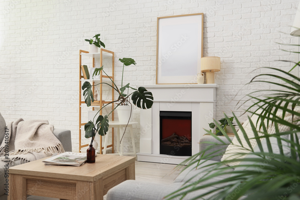 Fototapeta premium Interior of living room with fireplace, table and blank poster