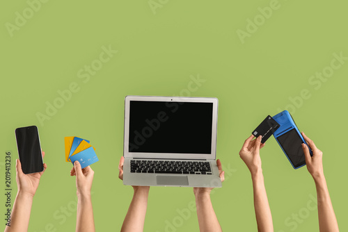 Quadro em tela Female hands with credit cards, gadgets and payment terminal on green background