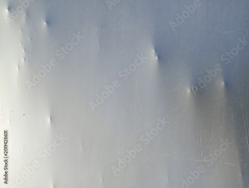Canvas Print Close-up of a dented or warped light-colored surface with multiple small bumps and a prominent puncture or deep indentation