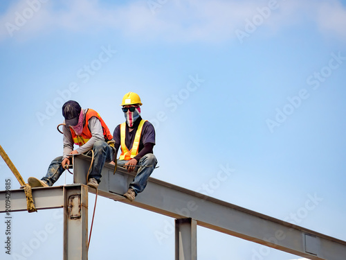 Construction workers resting on steel beam against sky