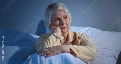 Foto Senior woman suffering from sleep deprivation in bedroom