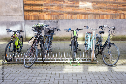 Принти на полотні Bicycles parked on the cobbled street on the city parking near modern house