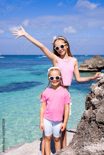 Two young girls enjoying a sunny day by the ocean