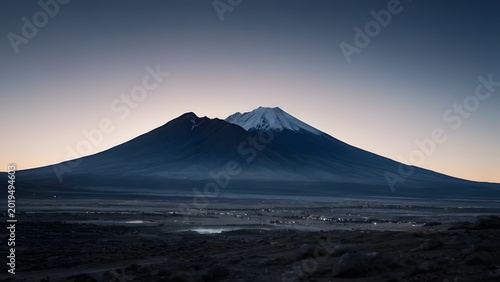 Majestic mountain peak at dawn with serene sky and atmospheric haze in vast desert landscape