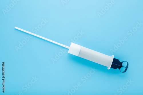 Obraz na plátně New universal plastic syringe for lawnmower engine oil change on light blue table background