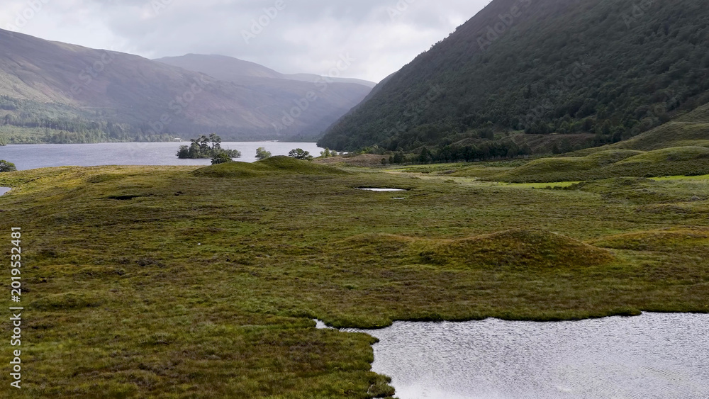 Fototapeta premium Aerial View of a Tranquil Loch and Green Meadows in Scotland