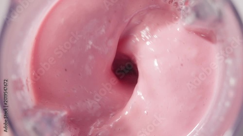 Strawberry and banana pink milkshake blended in blender with splashes. top view. slow motion. Healthy protein smoothie drink concept , food closeup