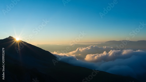 Mountain peak, sunrise above clouds, landscape photography, scenic view, natural wonder