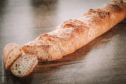 Photography still life with French fresh bread baguettes with poolish on a wooden cutting bo