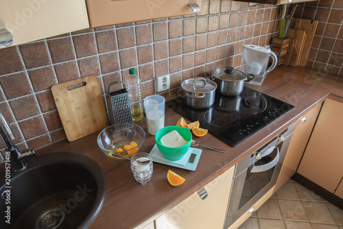 Quadro su tela A kitchen countertop with kitchenware, dishes, kitchen scales, and cooking accessories in a homey interior