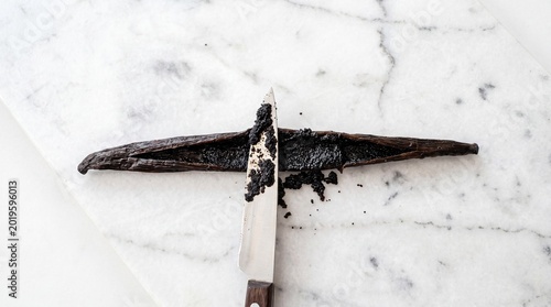 Scraping fresh vanilla seeds from a bean pod with a knife