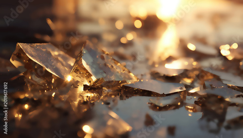 Shattered golden shards reflect bright sunlight with blurred background