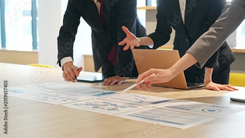 A group of business people having a meeting while looking at documents in the office.