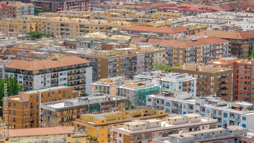 Quadro su tela Aerial view of a densely populated urban area featuring numerous multi story residential buildings with terracotta roofs and balconies, capturing a typical Mediterranean cityscape