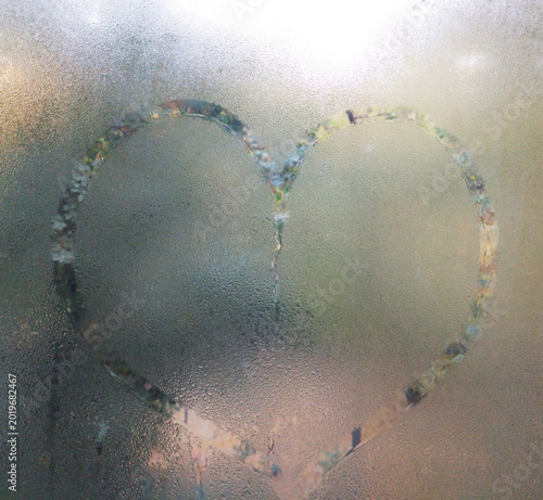 Autumn rain and a heart painted on misted glass. a symbol of love, devotion, friendship and sympathy. confession of feelings expressed in the picture on the window