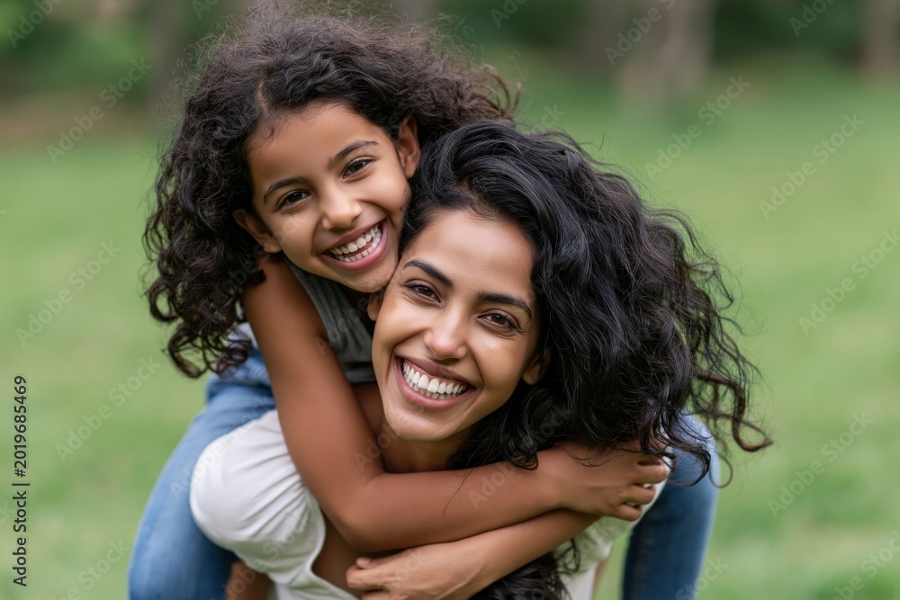 Naklejka premium Happy indian mother having fun with her daughter outdoor - Family people and love concept - Focus on mum face