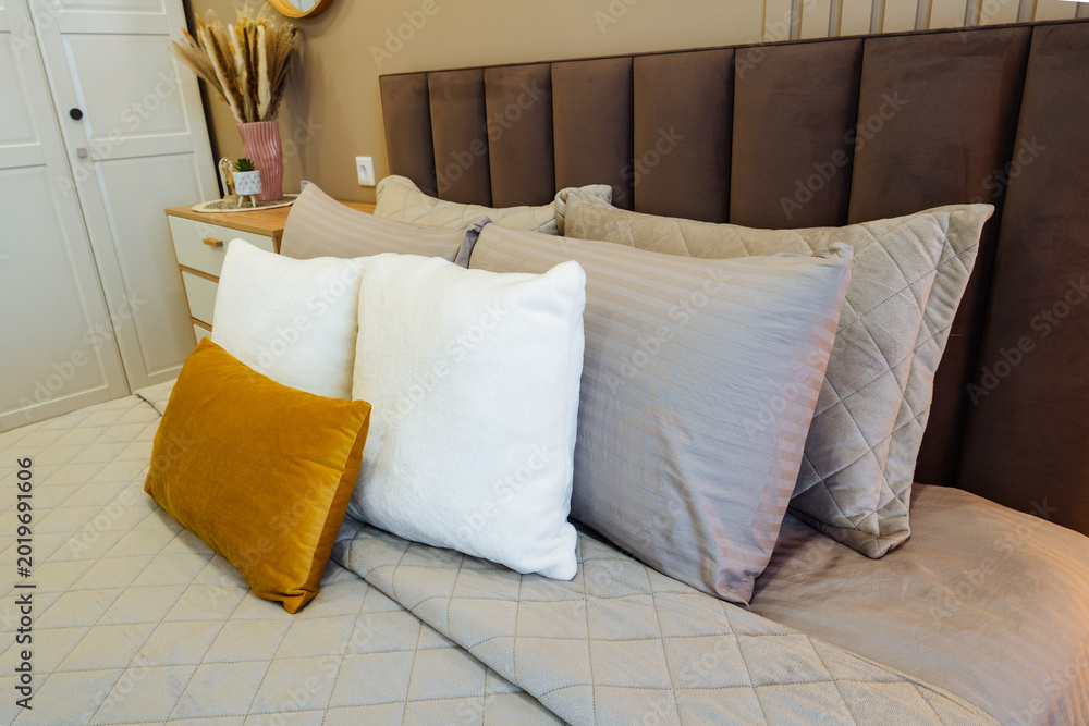 Fototapeta premium Luxurious and cozy bedding complemented by tasteful decorative accents. Refined bedroom design featuring soft furnishings and sophisticated decorative elements for relaxation