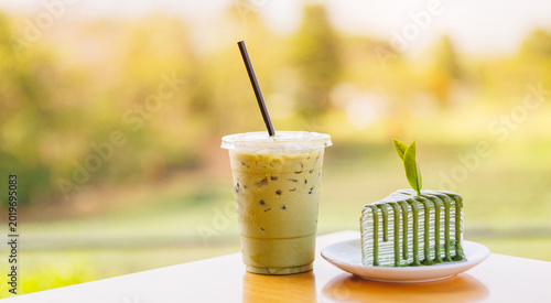 Schilderij op canvas Iced matcha drink with green tea crepe cake side by side on table for cafe banne