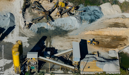 Konstfotografi Industrial quarry machinery depositing aggregate piles in aerial site