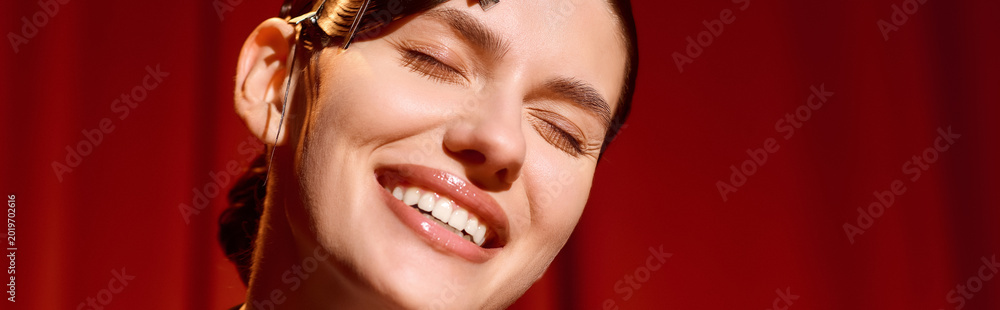 Naklejka premium Mesmerizing young woman radiates joy while performing on stage in a vibrant theatre setting