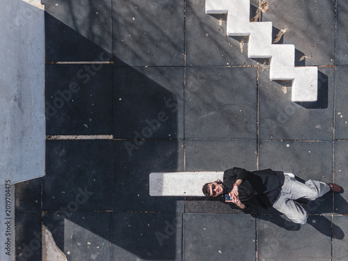 Concept of wireless technology. Top View of A man lying down using a smartphone.