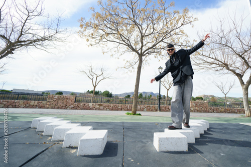 A young man walking outdoors on a geometric urban structure