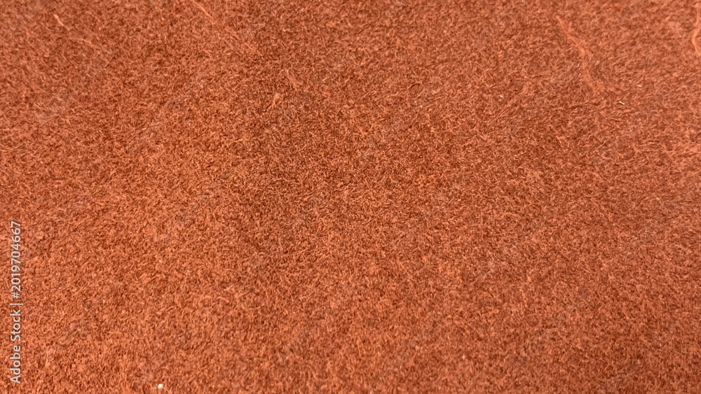 Fototapeta premium Close-up of reddish textured fibrous material with dense, uniform pattern and fine strands creating a rough surface appearance