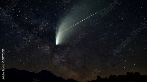 Comet streaking across starry night sky.