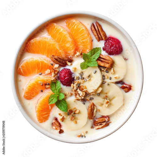 Overhead view of yogurt bowl with fruit, nuts, seeds, & garnish on a white bowl against a dark backdrop