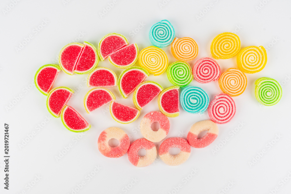 Fototapeta premium Swedish candies in a assorted piles with hearts, carrots, fruit rings, and licorice on white background. 