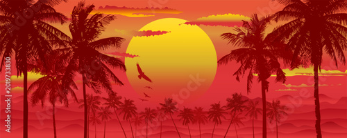 Tropical sunset setting sun and silhouette of palm trees and mountains in the background of with in a crimson and yellow gradient