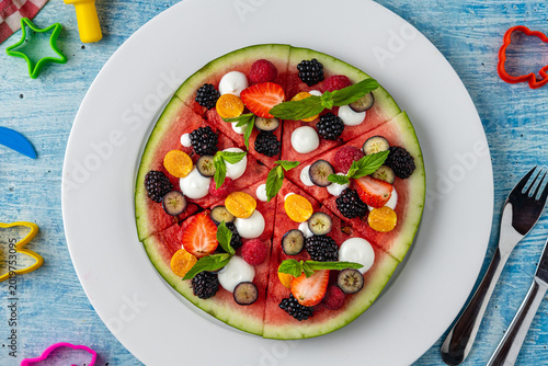 Creative watermelon pizza with fruits and berries for healthy kids snack