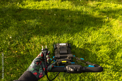 Photos Gardener Connecting Electric Lawn Mower to 220V Power Supply Wearing Protective