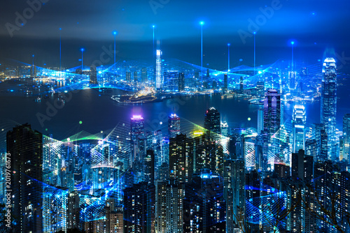 Futuristic smart city cityscape with visual digital data connection technology icons at night.